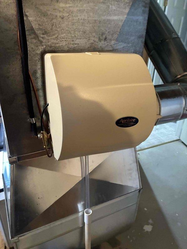 Performed diagnostic assessment on non-functioning Aprilaire humidifier unit mounted to customer's HVAC system. Inspection revealed electrical connection issues at the junction point where multiple wires (blue, red, white) were improperly connected. Repaired wiring connections to restore proper operation of the humidifier system.