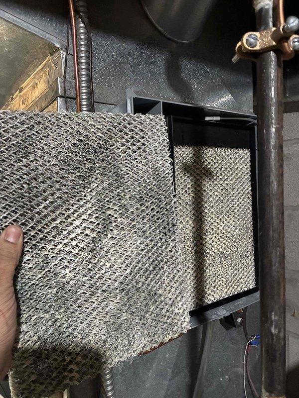 Responded to service call regarding continuous water drainage from Aprilaire whole-house humidifier. Inspected system and found severely clogged air filter causing improper system operation. Serviced humidifier components and replaced filter to restore proper functionality and eliminate water waste issue.