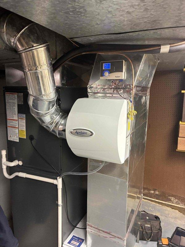 Performed scheduled monthly maintenance on heating system. Inspected and found dirty pleated air filter in need of replacement. Examined Aprilaire humidifier unit and associated ductwork, confirming proper installation and operation of control panel with blue LCD display.