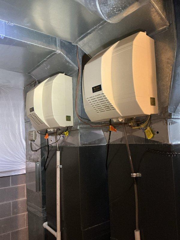 Performed scheduled heating maintenance service on dual-system HVAC setup. Inspected and verified proper operation of both humidifier units mounted on ductwork, confirming all connections and drainage systems were intact. Examined blower motor assembly, checked all electrical connections for security, and verified proper wiring configuration to control modules.