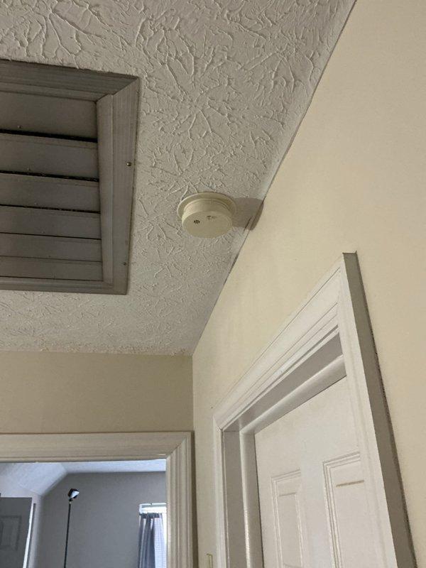 Performed inspection and replacement of smoke detectors in residence. Diagnosed electrical grounding issue in one room causing surge protectors to display error indicators. Corrected inverted light switch operation for outdoor lighting fixture.