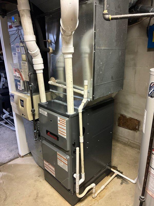Successfully installed new Amana furnace with 3" PVC flue system for exhaust and air intake in basement utility room. Completed comprehensive setup including humidifier integration and installation of four thermostats. All components properly mounted with appropriate connections to existing ductwork.