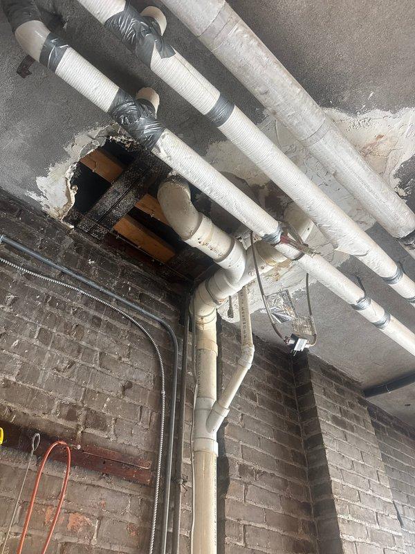 Conducted comprehensive plumbing inspection of outdoor water supply system. Examined PVC piping configuration and identified areas of water damage where pipes penetrate ceiling. Observed potential leak indicators including white mineral deposits at pipe joints and inspected insulation integrity on water lines.