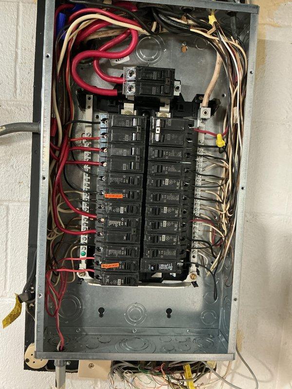 Conducted comprehensive electrical panel inspection, documenting the condition of circuit breakers, wiring connections, and safety labels. Panel showed proper installation with appropriate hot, neutral, and ground wire configuration, though some areas near the utility basin showed minor water damage and rust on nearby plumbing components.