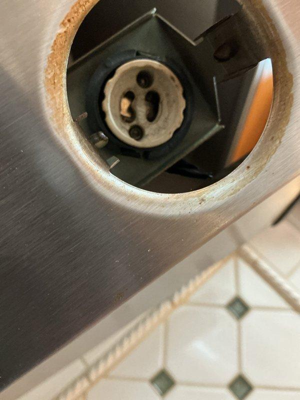 Replaced corroded hood light socket in exterior lighting fixture. Removed damaged component showing significant rust and discoloration, installed new socket with proper wiring connections. Verified proper operation of light after installation.