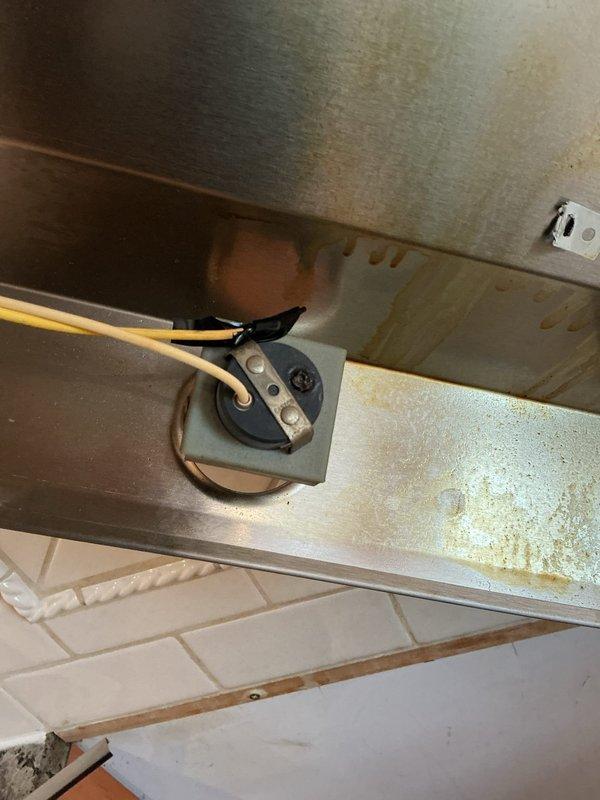 Replaced corroded hood light socket in exterior lighting fixture. Removed damaged component showing significant rust and discoloration, installed new socket with proper wiring connections. Verified proper operation of light after installation.