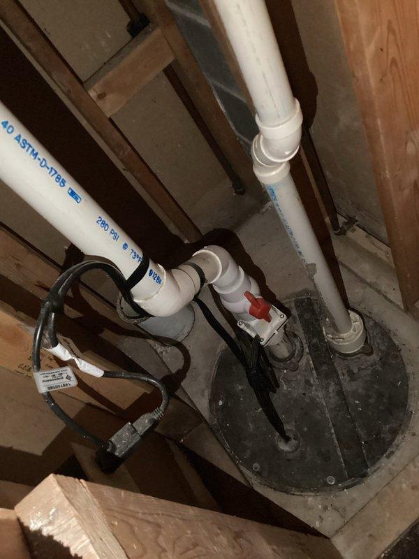 Conducted comprehensive plumbing inspection of sump pump system with associated PVC drainage pipes and examined aging copper supply lines showing significant oxidation and mineral buildup. Documented condition of brass fittings and pipe securing mechanisms for future reference.