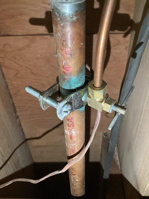 Conducted comprehensive plumbing inspection of sump pump system with associated PVC drainage pipes and examined aging copper supply lines showing significant oxidation and mineral buildup. Documented condition of brass fittings and pipe securing mechanisms for future reference.