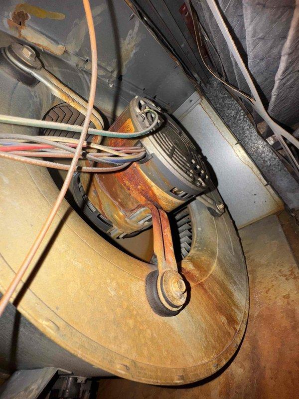 Performed scheduled maintenance on dual heating systems. Observed significant corrosion and rust on heat exchanger panel and blower housing. Noted motor and electrical connections remain functional despite age-related wear on equipment.