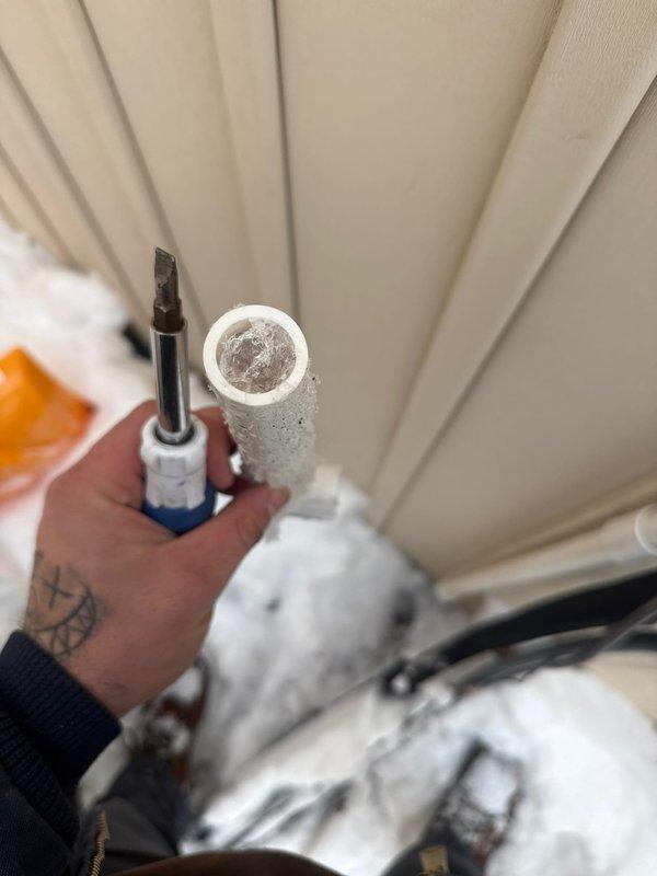 Responded to no hot water complaint for tankless water heater. Discovered frozen inlet water pipe due to extreme cold weather conditions. Thawed frozen pipe and restored water flow to unit, allowing system to resume normal operation. Advised customer on preventative measures to protect exterior plumbing components during freezing temperatures.