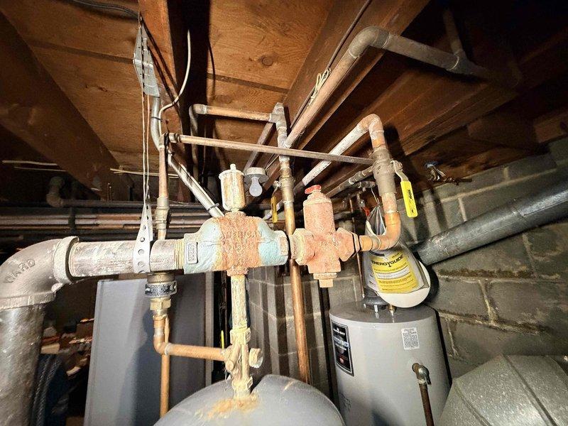 Diagnosed issues with customer's non-functioning boiler system upon inspection. Identified significant corrosion and rust on cross-junction valve assembly and evaluated the Bradford White water heater system with multiple expansion tanks. Determined cartridge circulator replacement was necessary to restore proper system operation.