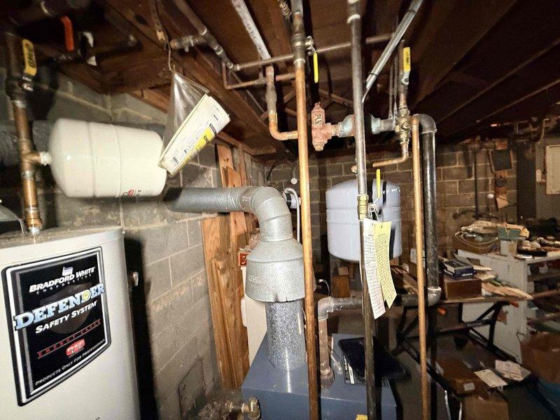 Diagnosed issues with customer's non-functioning boiler system upon inspection. Identified significant corrosion and rust on cross-junction valve assembly and evaluated the Bradford White water heater system with multiple expansion tanks. Determined cartridge circulator replacement was necessary to restore proper system operation.