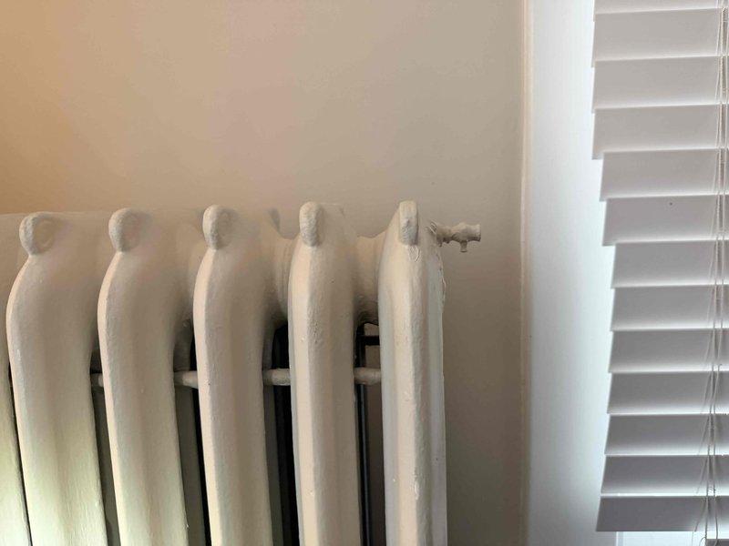 Repaired leaking radiator valve on a traditional cast iron heating unit. Serviced the valve assembly which showed signs of corrosion and wear. System now functioning properly with no leaks detected.