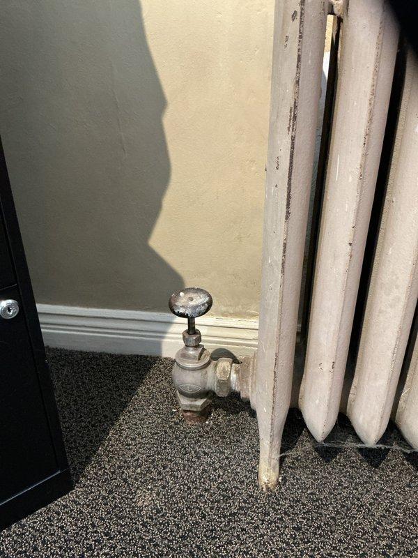 Responded to service call regarding two non-operational radiators. Performed inspection of affected cast iron radiators with manual control valves showing signs of age. Corrected issue by cleaning valve connections where blue residue was present, restoring proper heat flow to both units.