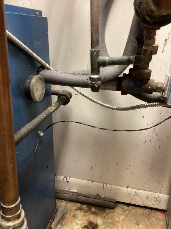 Completed repair of leaking elbow on fin tube heating element adjacent to garage door. Isolated boiler from system, capped piping and pressurized to 30 psi for leak test. Addressed significant water damage at baseboard connection point where deterioration had occurred to surrounding wall material and floor surface.