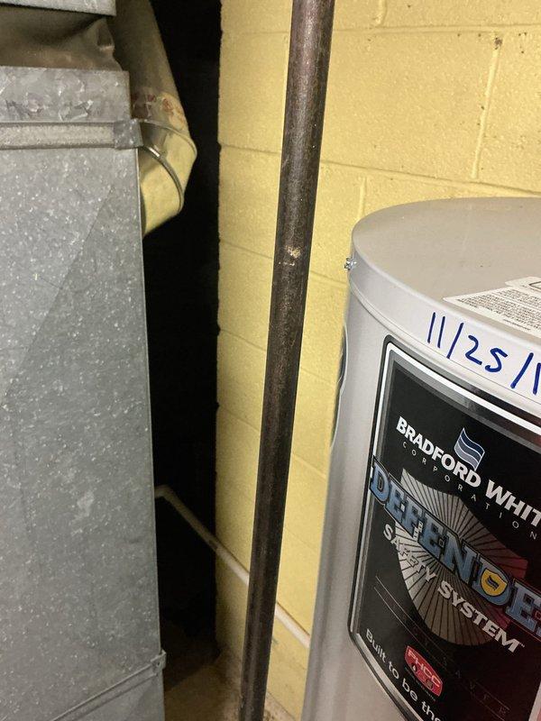 Inspected humidifier leakage issue on HVAC system located in utility room. Performed diagnostic assessment of the Bradford White Defender system and associated ductwork connections. Documented condition of metal vent piping and water heater integration for comprehensive evaluation.