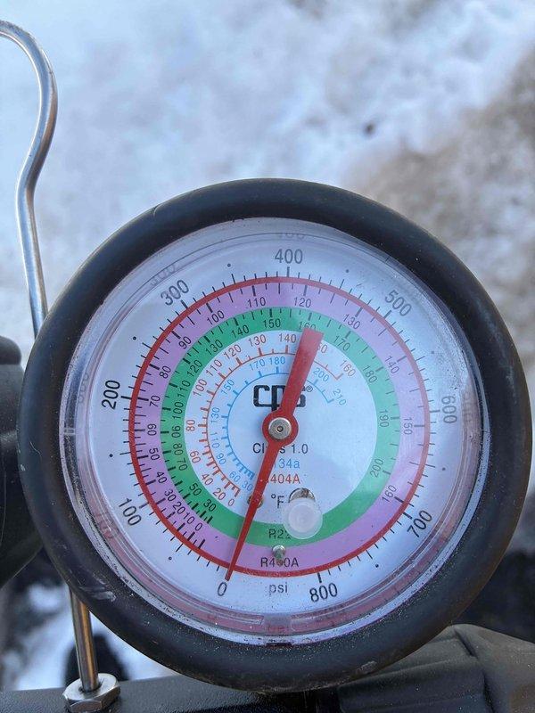 Responded to customer concern regarding thermostat alert indicating low refrigerant in heat pump. Performed pressure testing with manifold gauges and verified refrigerant levels for R410A system were within manufacturer specifications. No refrigerant leak detected; thermostat sensor reading was determined to be faulty.