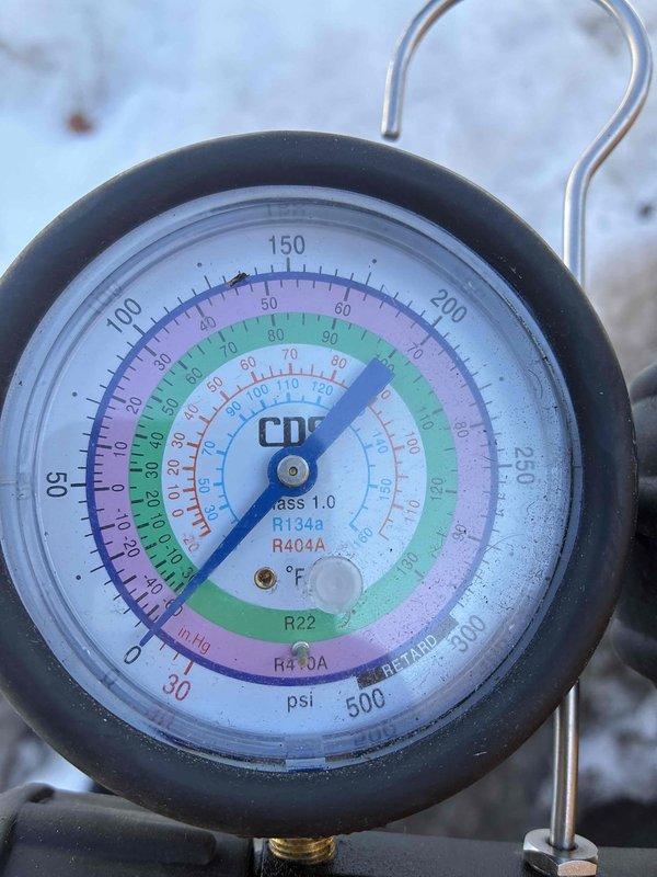 Responded to customer concern regarding thermostat alert indicating low refrigerant in heat pump. Performed pressure testing with manifold gauges and verified refrigerant levels for R410A system were within manufacturer specifications. No refrigerant leak detected; thermostat sensor reading was determined to be faulty.
