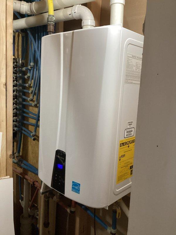 Completed scheduled maintenance on wall-mounted tankless water heater system. Inspected all plumbing connections including hot/cold water lines, gas supply lines with shutoff valves, and PVC venting. Verified proper operation of unit and control panel functionality.