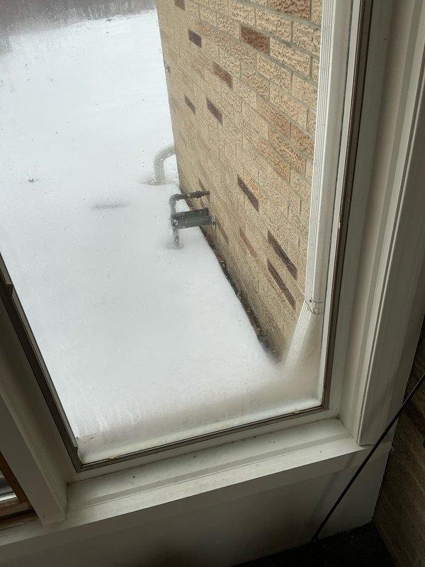 Conducted site assessment for garage heater installation where no existing system was in place. Performed temperature measurements using digital testing equipment, with readings of 28.3° and 26.8° recorded. Noted significant window condensation issues in the space requiring climate control.