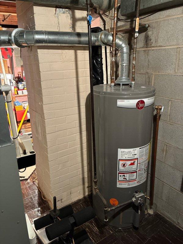 Conducted furnace replacement consultation for client with existing older HVAC system. Inspected current installation including water heater configuration in utility area and evaluated existing thermostat (battery-operated model displaying 25°). Presented replacement options for furnace while noting AC unit is also aging but not prioritized by client due to minimal usage.