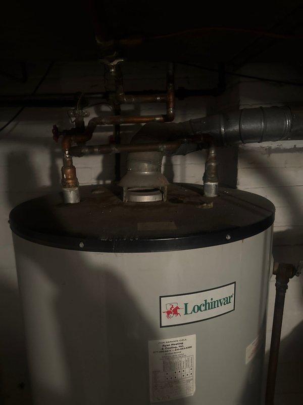 Completed estimate for replacement of 100-gallon Lochinvar water heater system located in basement utility room. Documented existing installation including copper piping configuration, inlet/outlet connections, and associated valves. Photographed current unit for accurate specifications to ensure proper sizing for replacement proposal.