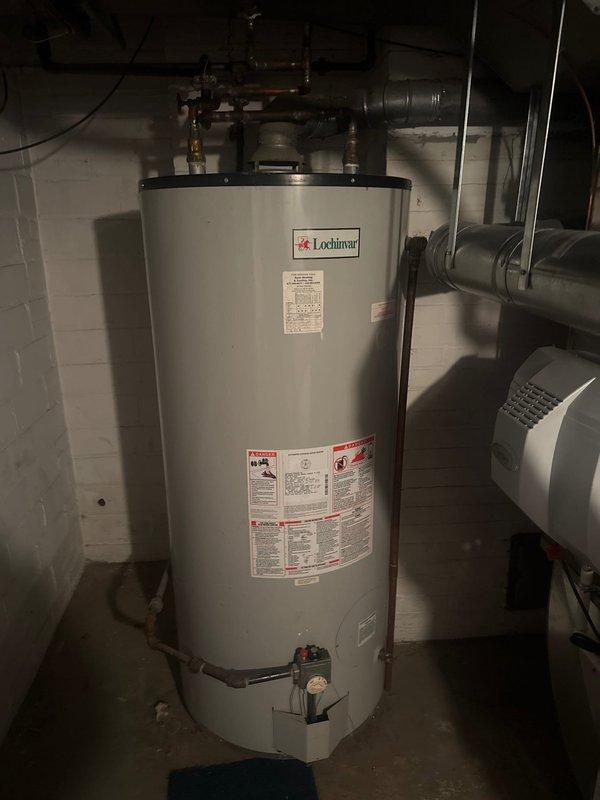 Completed estimate for replacement of 100-gallon Lochinvar water heater system located in basement utility room. Documented existing installation including copper piping configuration, inlet/outlet connections, and associated valves. Photographed current unit for accurate specifications to ensure proper sizing for replacement proposal.