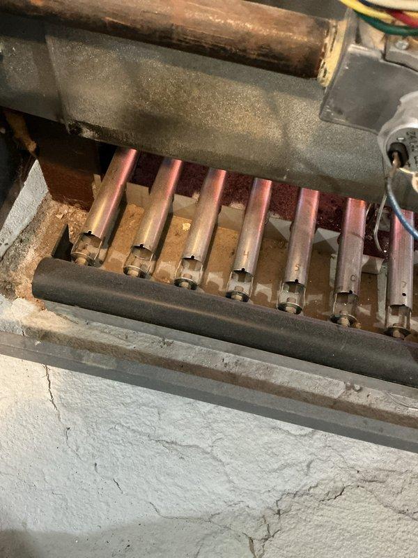 Performed scheduled maintenance on water boiler system. Inspected burner tubes and heat exchanger for proper operation, noting some aging in the mounting surface with visible cracks. Examined expansion tanks and air eliminators connected to copper and PVC piping, observing minor corrosion on copper sections while confirming all components remain functional.