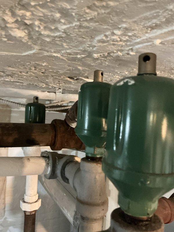 Performed scheduled maintenance on water boiler system. Inspected burner tubes and heat exchanger for proper operation, noting some aging in the mounting surface with visible cracks. Examined expansion tanks and air eliminators connected to copper and PVC piping, observing minor corrosion on copper sections while confirming all components remain functional.