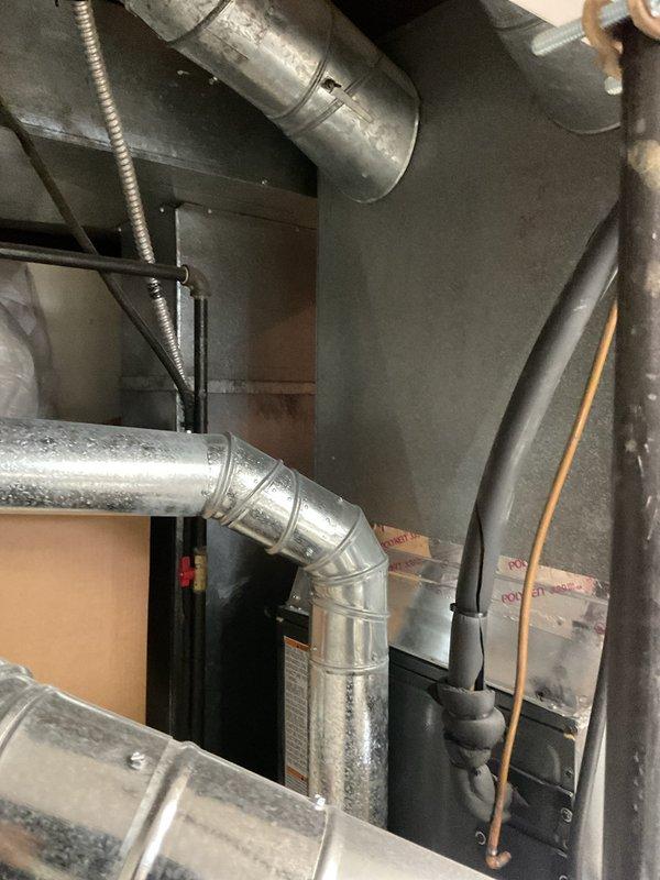 Completed first-year heating system maintenance inspection. Examined wiring connections at control board and terminal block, confirming proper wire routing and secure connections. Inspected ductwork integrity, including main trunk line and elbow joints, with particular attention to seams and connection points. All components appear properly installed with no visible issues.