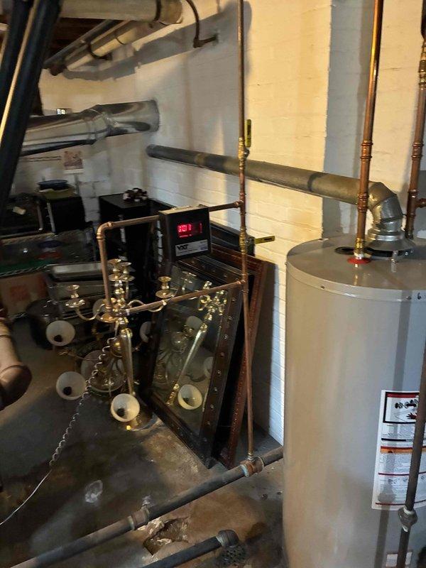 Performed routine heating tune-up on residential HVAC system, including inspection of mechanical components and connections. Examined hot water heater installation with particular attention to copper piping, brass fittings, and pressure gauge readings. System pressure reading observed at 127, all components functioning within normal parameters.