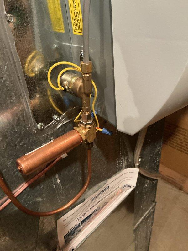 Responded to customer complaint regarding uneven heating and cold air during furnace startup. Inspected Honeywell ProSeries thermostat which was operating normally at 73°F in heat mode. Examined plumbing connections to the HVAC system, including copper piping, brass valve assemblies, and pressure regulator, finding all components properly installed and functioning correctly.