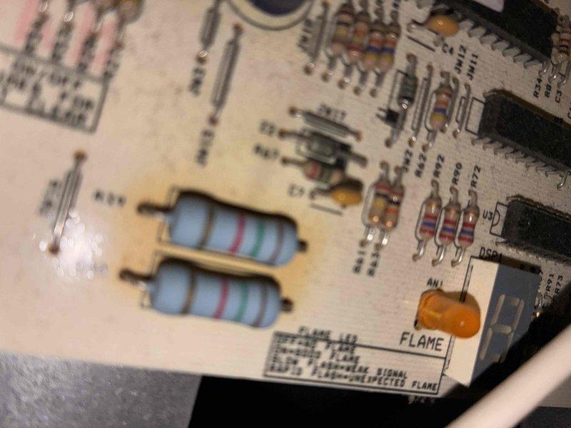 Completed routine heating system maintenance, inspecting the flame sensor circuit board for proper operation. Performed electrical testing using clamp meter, measuring 0.79 amps on control components. All systems functioning within normal parameters.