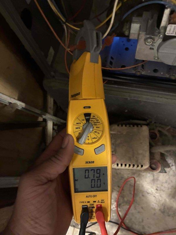 Completed routine heating system maintenance, inspecting the flame sensor circuit board for proper operation. Performed electrical testing using clamp meter, measuring 0.79 amps on control components. All systems functioning within normal parameters.