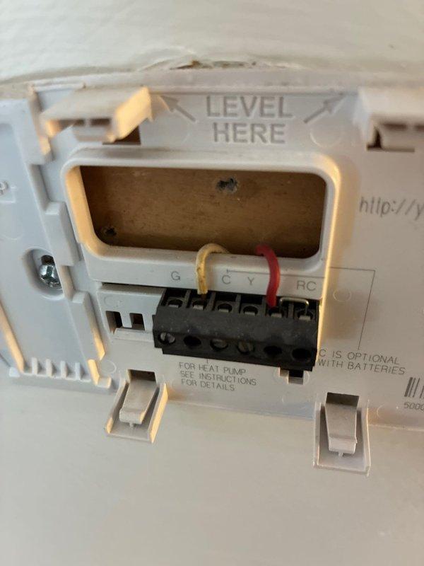 Inspected existing Honeywell thermostat installation, revealing issues with wiring connections at terminal block. Evaluated compatibility requirements for replacement system and documented current setup which includes heat pump configuration with specific wire connections (G, C, Y, RC terminals).