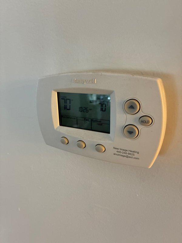 Inspected existing Honeywell thermostat installation, revealing issues with wiring connections at terminal block. Evaluated compatibility requirements for replacement system and documented current setup which includes heat pump configuration with specific wire connections (G, C, Y, RC terminals).