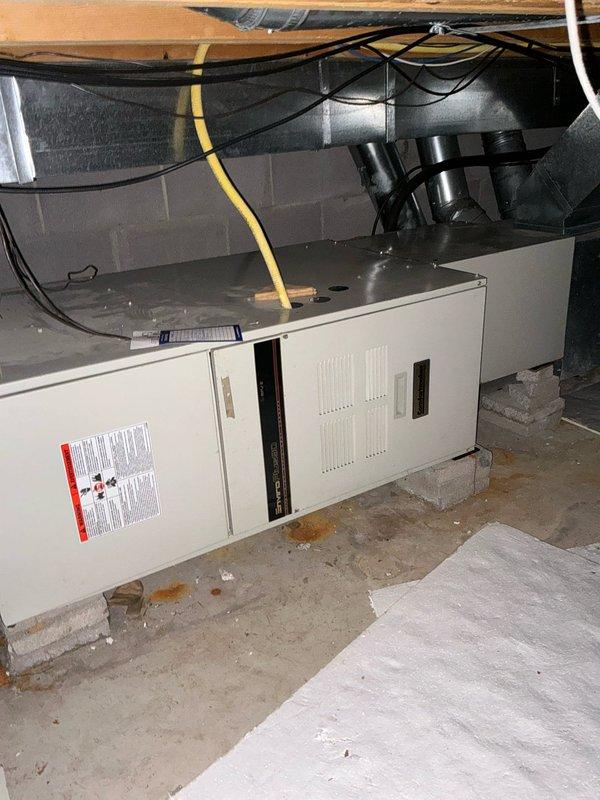 Conducted comprehensive assessment of existing furnace system in basement utility area. Evaluated aging unit mounted on concrete blocks with multiple duct connections and visible wear. Inspected electrical components in crawlspace, noting junction box condition and wiring requirements for potential replacement options. Documented furnace/AC replacement alternatives for client consideration.