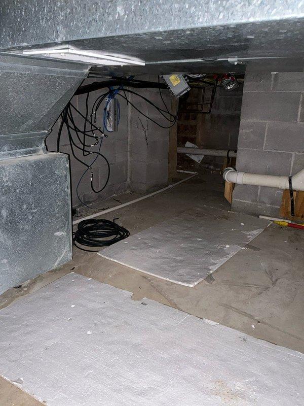 Conducted comprehensive assessment of existing furnace system in basement utility area. Evaluated aging unit mounted on concrete blocks with multiple duct connections and visible wear. Inspected electrical components in crawlspace, noting junction box condition and wiring requirements for potential replacement options. Documented furnace/AC replacement alternatives for client consideration.