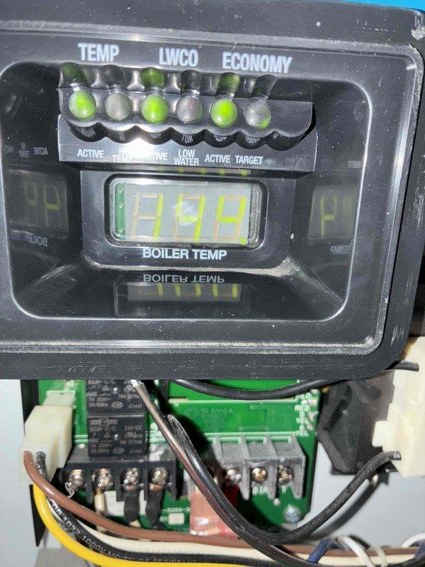 Responded to no-heat service call on boiler system. Inspected control panel displaying 199°F boiler temperature with functional status indicators. Verified proper operation of LWCO safety system and terminal connections on the main control board, confirming all wiring was secure and the boiler was operating normally after service.