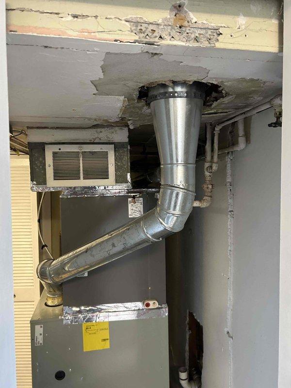 Completed flue repair for water heater system and installed new expansion tank on Rheem Performance unit. Repaired damaged ceiling and ductwork connection where galvanized steel components meet the air handler. Two-person crew executed all necessary plumbing connections including shut-off valve installation and proper pipe securing to ensure code-compliant operation.
