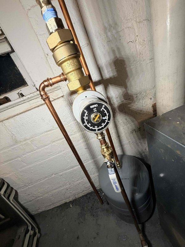 Returned to complete previously scheduled repair that was delayed due to frozen conditions. Successfully replaced pressure reducing valve (PRV) and backflow preventer on boiler system located in addition. Installed new components with proper connections to copper supply lines and verified system pressure readings were within normal operating range.