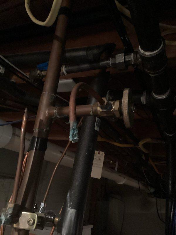 Conducted comprehensive inspection of residential plumbing system with focus on copper pipe network showing signs of corrosion at multiple joints. Documented significant turquoise discoloration on copper fittings connected to main PVC supply line and examined TurboTwin control valve for proper functionality. Identified potential issues with pipe insulation on hot water lines and verified structural integrity of mounting hardware supporting the installation.