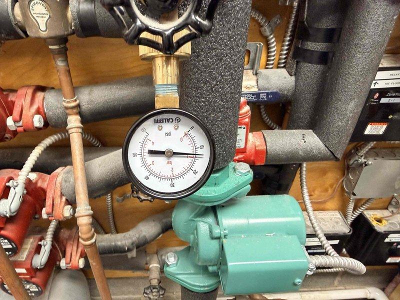 Performed comprehensive boiler maintenance inspection including pressure system verification (0-100 psi gauge reading normal), circulation pump assessment, and examination of all control valves and piping connections. Cleaned and inspected air intake filter which showed moderate debris accumulation. System currently operational but documented findings for disclosure purposes related to pending property sale.