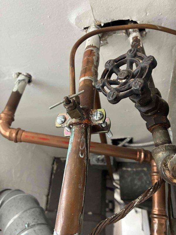 Diagnosed and assessed 9-month-old water heater exhibiting significant leakage from top and bottom connections with visible rust formation. Inspection of copper supply lines revealed aging connections with mineral deposits and surface corrosion contributing to the leak severity. Documented deteriorating installation with photographic evidence for warranty claim consideration.