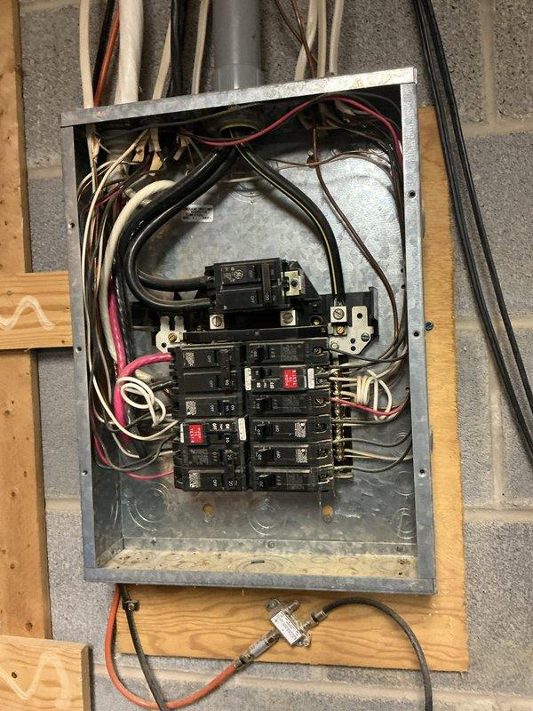 Conducted comprehensive electrical panel inspection in basement utility area. Panel inspection revealed properly connected circuit breakers with appropriate wiring configuration, though panel showed signs of crowded wire management. Adjacent plumbing and HVAC systems were noted with no apparent electrical hazards or code violations observed.