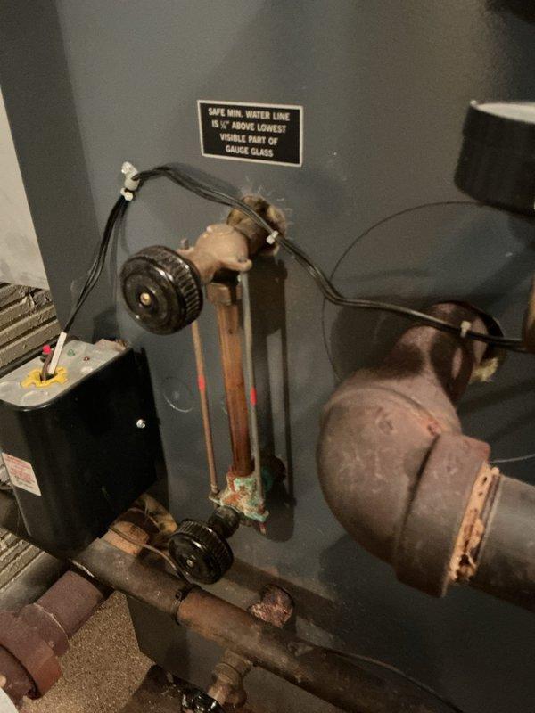 Responded to emergency service call for a severely leaking boiler. Upon inspection, identified water level issues as indicated by the gauge glass, which was below the safe minimum water line (5/8" above lowest visible part). Repaired leaking connections at pipe joints and restored proper water level in the system to manufacturer specifications.