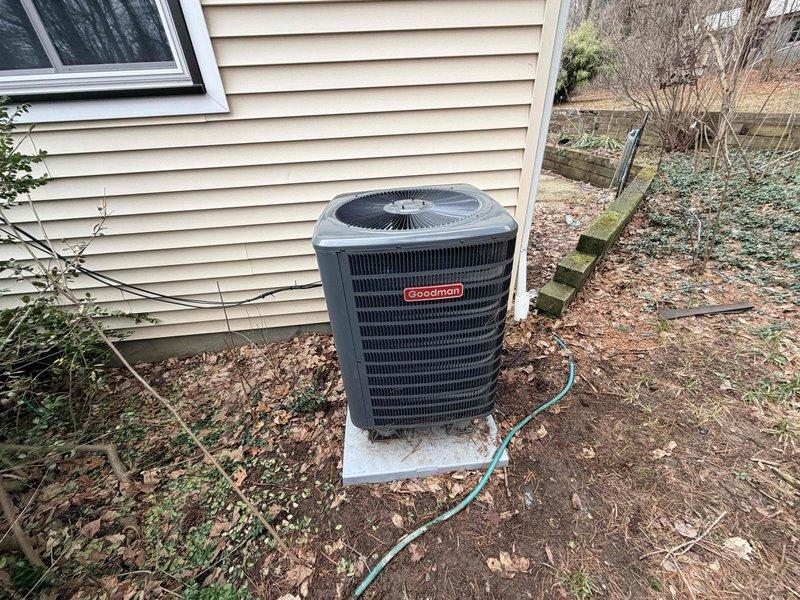 Diagnosed communication failure between thermostat and Goodman heat pump resulting in no heat operation. Inspected outdoor unit and found accumulated debris in coil assembly affecting performance. Cleaned debris from system components and restored proper communication between thermostat and heat pump, returning heating functionality to normal operation.