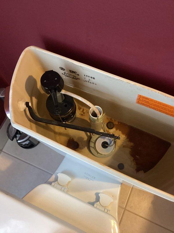 Conducted comprehensive plumbing inspection of bathroom fixtures, examining toilet tank components and under-sink plumbing assembly. Noted mineral buildup and staining in Kohler toilet tank with functioning but aged float ball mechanism and flush valve assembly. Verified integrity of sink's PVC P-trap and braided supply lines with no signs of leakage or deterioration.