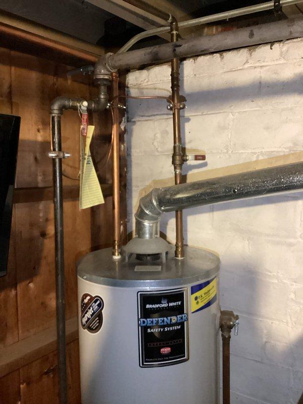 Responded to a service call for a water heater leak. Upon inspection, identified a 20-year-old Bradford White "Defender" tank with significant bottom leakage. Diagnosed terminal failure requiring full replacement. Provided customer with replacement options and documented current installation configuration with photos for proper sizing and connection planning.