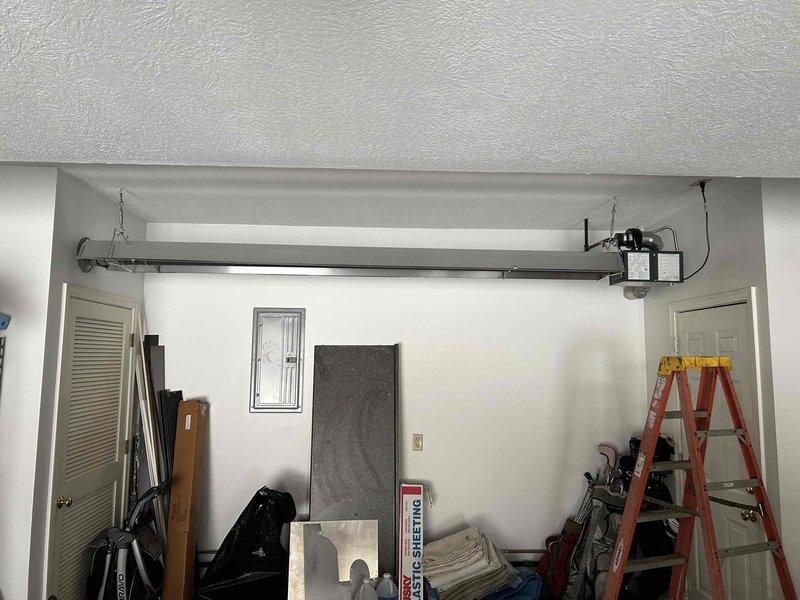 Completed installation of ceiling-mounted garage heater with proper ductwork connections. Installed black rectangular supply plenum with galvanized round takeoff, ensuring secure mounting to textured ceiling. Final inspection confirmed proper functionality and collected payment.